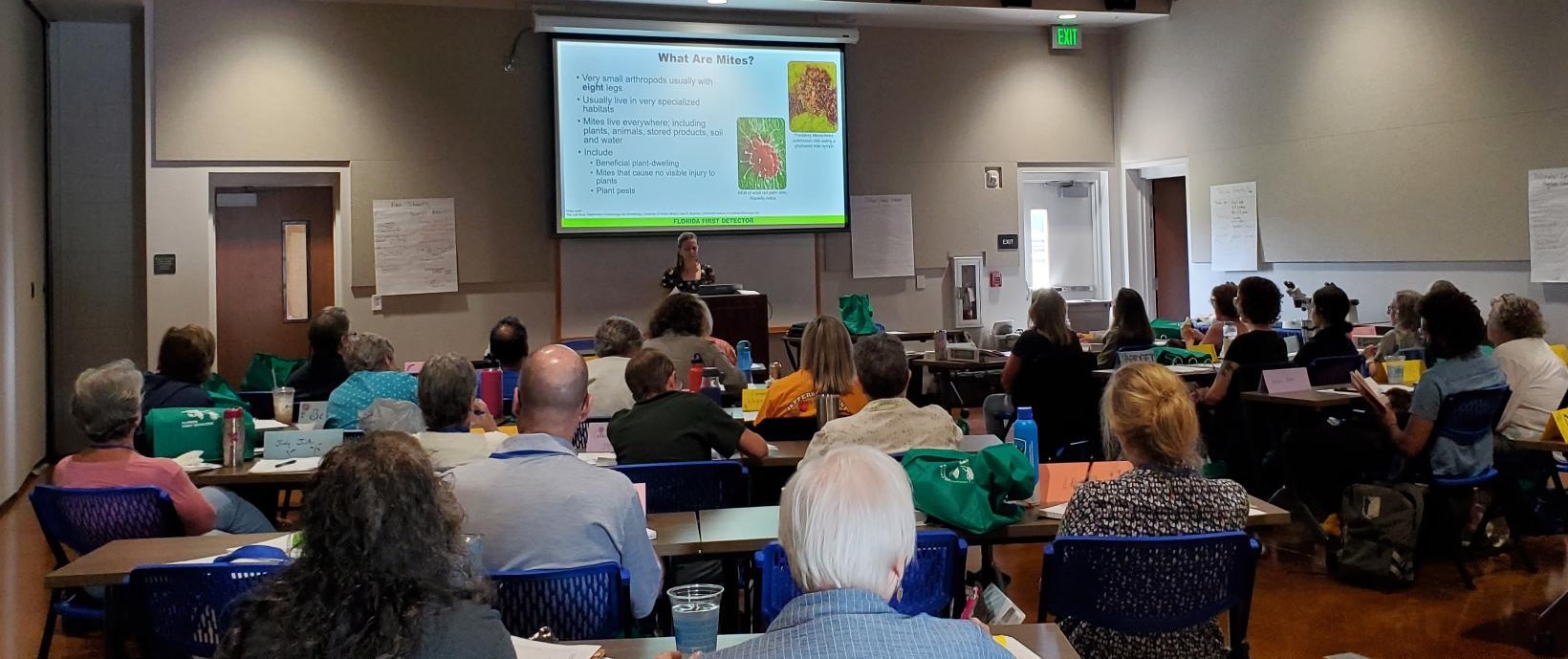 a student giving a presentation on mites to audience of people